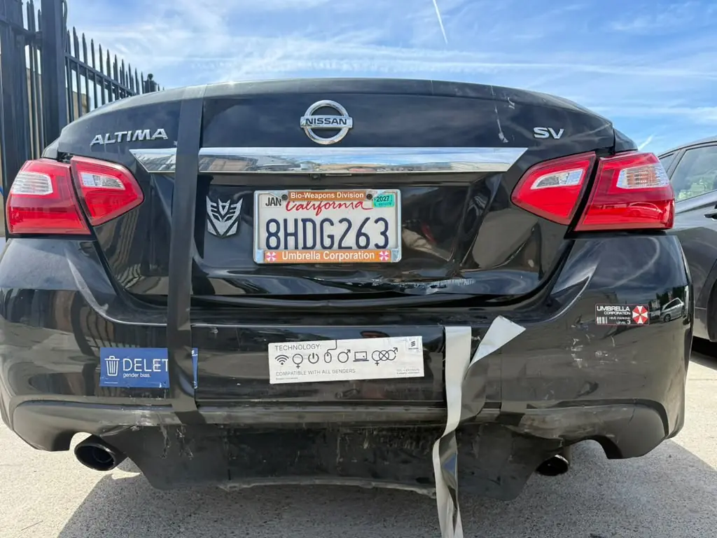 Black Nissan Altima with a crushed rear bumper, before repair