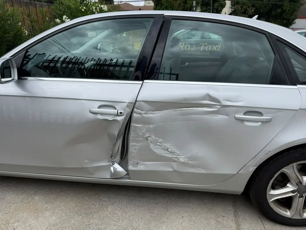 Silver Audi A4 with crushed doors, before repair