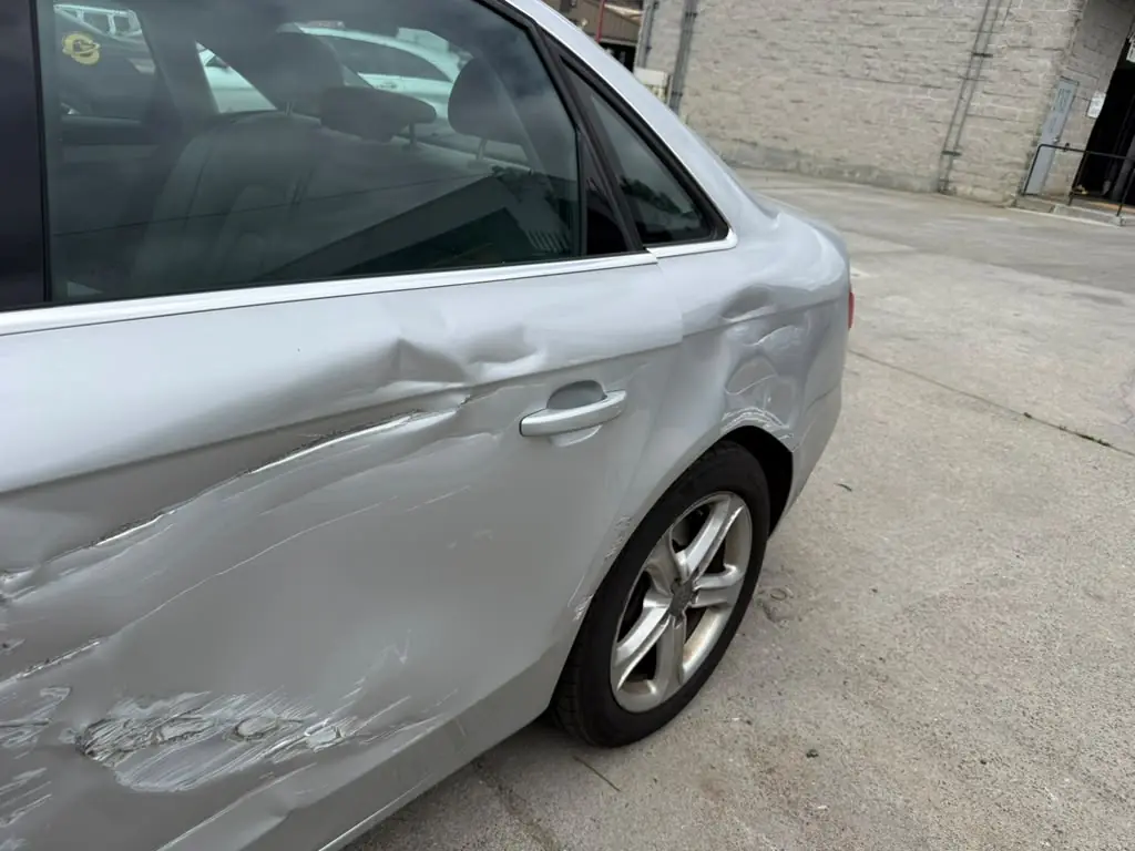 Deep crease along an Audi door, before dent repair