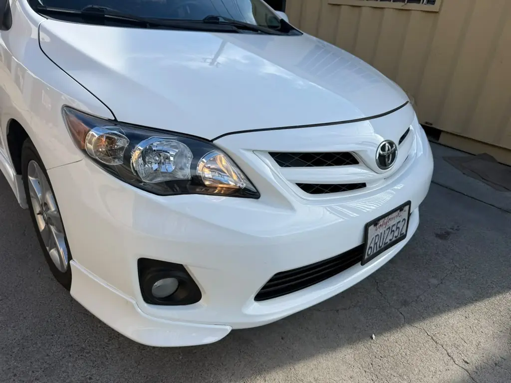White Toyota Corolla after repair, front three-quarter view