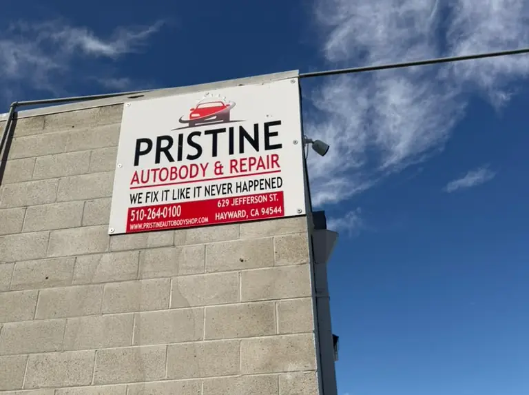 Pristine Autobody & Repair sign on the shop building in Hayward