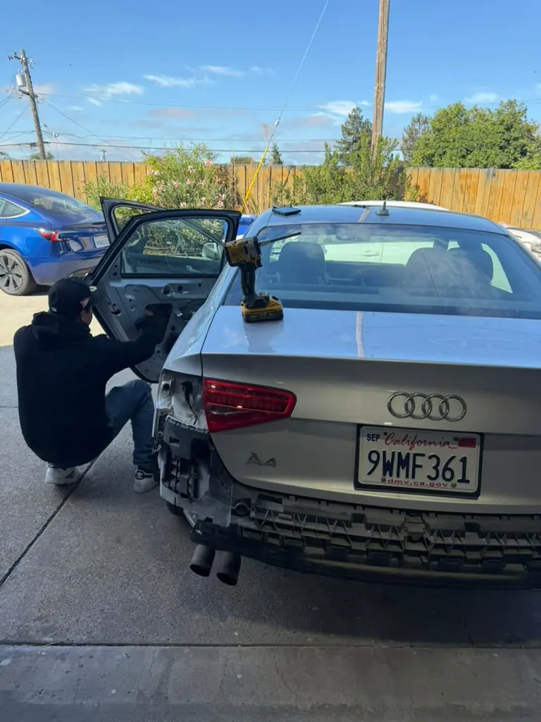 Technician working on the rear of a silver Audi A4