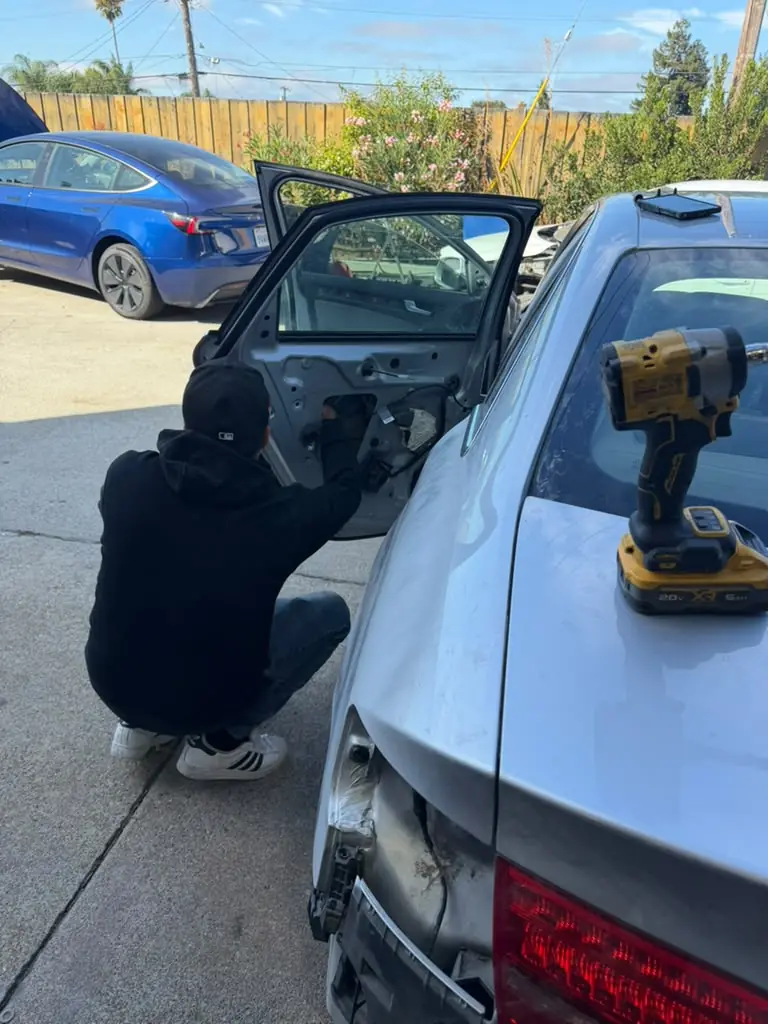 Technician repairing the door of a silver Audi