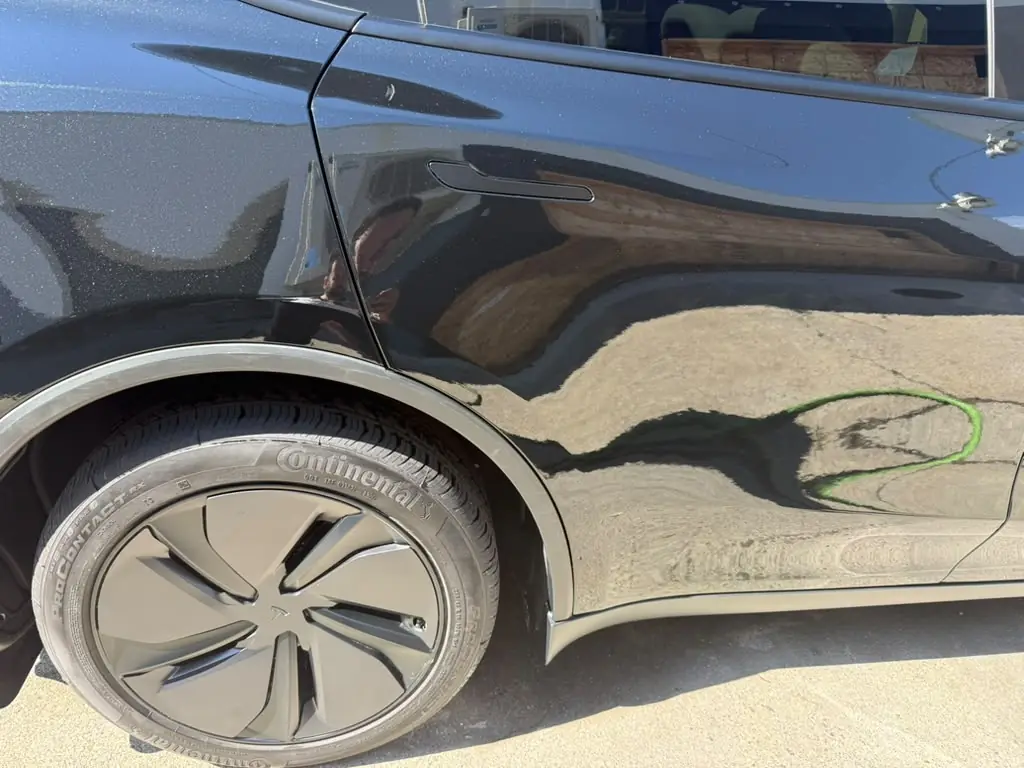 Finished black Tesla rear quarter panel after paint